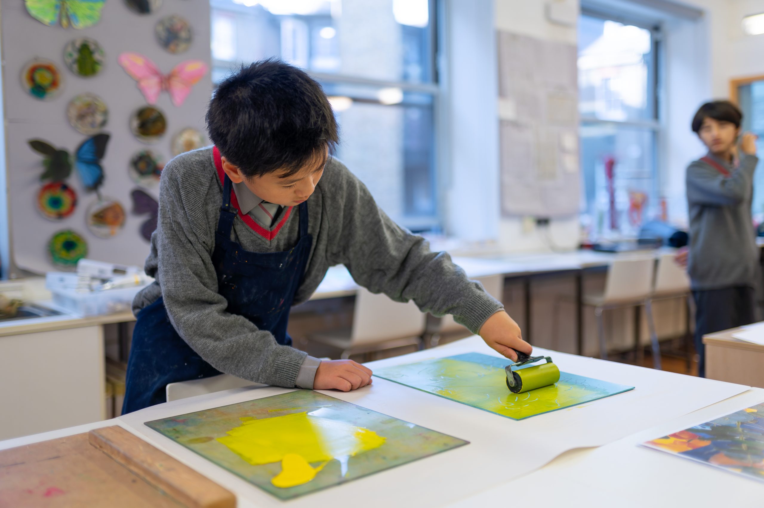 Pupil appling screen printing during art lesson