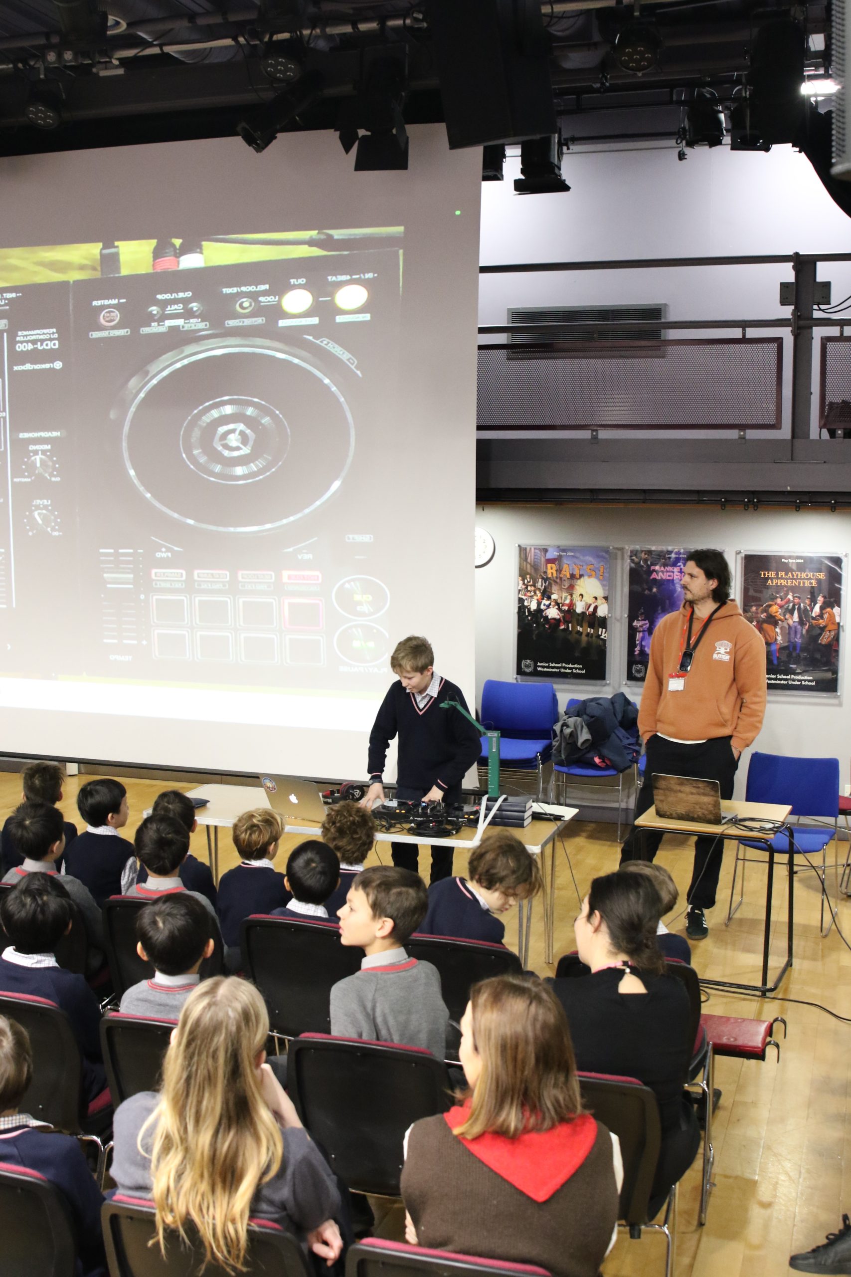 Pupil DJing alongside guest DJ during assembly.